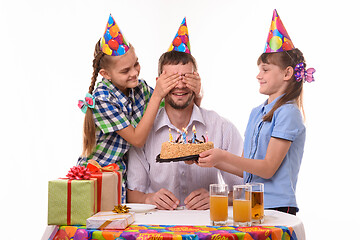 Image showing Children give a sweet surprise to dad at a birthday party