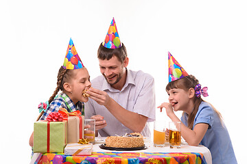 Image showing Dad and kids have fun eating cake at the festive table