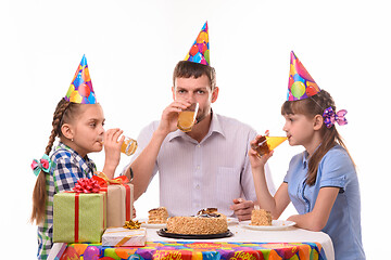 Image showing Dad and two daughters drink juice at the festive table