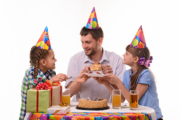 Image showing Dad puts a piece of holiday cake on a plate and looks at his daughter