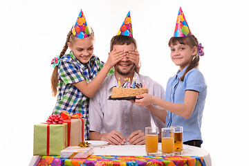 Image showing The children closed their eyes to dad and prepared a surprise for him in the form of a cake with candles