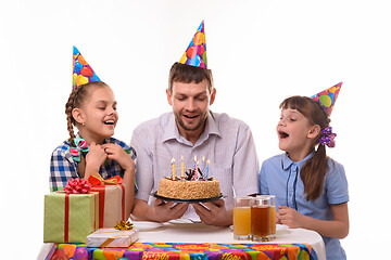 Image showing Dad and two daughters took a little more air to blow out the candles on the holiday cake