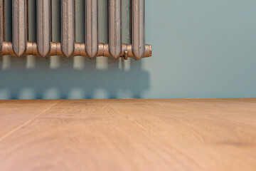 Image showing Natural wooden parquet and cast iron radiator