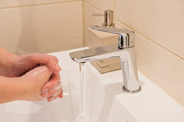 Image showing Washing of hands with soap under running water