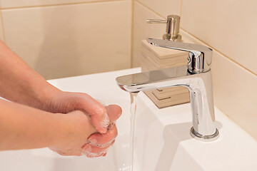 Image showing Washing of hands with soap under running water