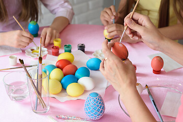 Image showing Family decorates chicken eggs on the table for Easter, close-up