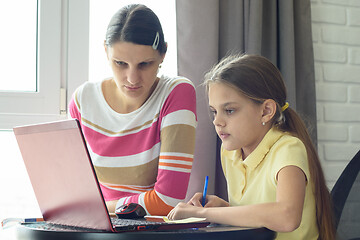 Image showing Mom and daughter solve homework using online distance learning