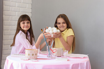 Image showing Children hold a large plate with chicken eggs before coloring for Easter