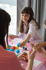 Image showing Happy child paints Easter eggs with his family