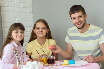 Image showing Happy family paints easter eggs at the table and looked joyfully into the frame