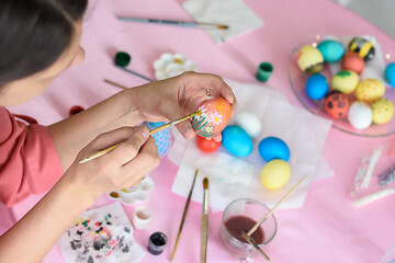 Image showing Girl paints chicken eggs for Easter