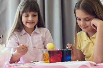 Image showing Children paint Easter eggs in glasses with liquid dye