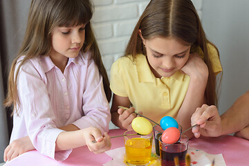 Image showing Children stain eggs in a special dye in glasses