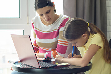 Image showing Mom helps daughter do homework