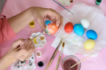 Image showing Hand paints eggs for Easter holiday.