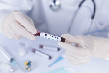 Image showing Doctor hands with protective gloves holding COVID 19 Coronavirus