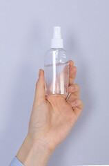 Image showing Close up woman hands using hands sanitizer alcohol gel