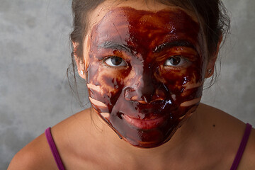 Image showing young asian girl having fun with a chocolate mask