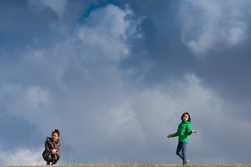 Image showing Cute girl running jumping at the on a field in the summer