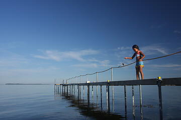 Image showing Cute girl fishing crabs at the beach in the summer