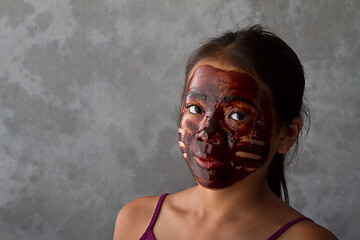 Image showing young asian girl having fun with a chocolate mask