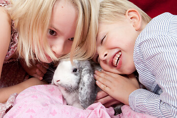 Image showing Portrait of a brother and sister in studio with a rabbit