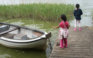 Image showing Sisters palying in the nature with a boat