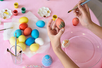 Image showing Female hand paints easter eggs, close-up