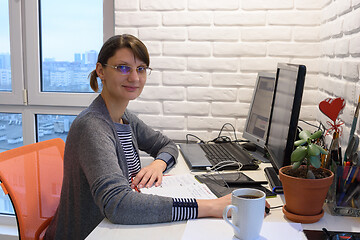 Image showing Happy girl working remotely at home looked into the frame