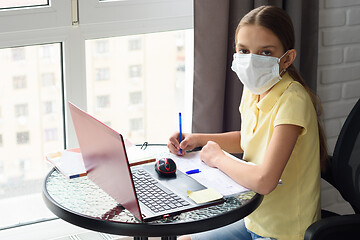 Image showing Girl in self-isolation studying online sitting by the window at home