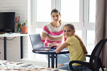 Image showing The tutor is teaching the child, both looked into the frame