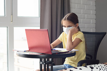 Image showing Girl in self-isolation at home sitting at the table and doing homework