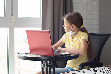 Image showing Girl in self-isolation studies at a laptop and looks out the window