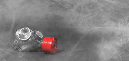 Image showing Vintage gasmask isolated on black - Smoke in the room - Red filt