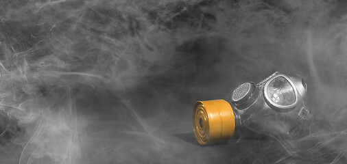 Image showing Vintage gasmask isolated on black - Smoke in the room - Orange f