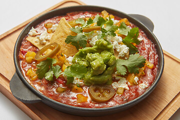 Image showing Close-up view pan with Shakshuka dish with spicy sauce from tomatoes.