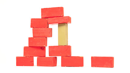 Image showing Vintage red building blocks isolated on white, one standing out