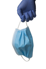 Image showing Gloved hand holding a surgical mask