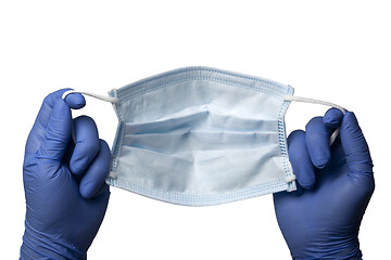 Image showing Gloved hands holding a surgical mask