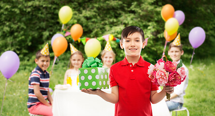 Image showing boy with gift box and flowers at birthday party