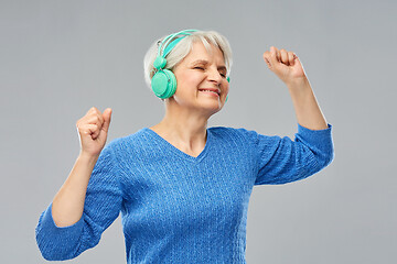 Image showing senior woman in headphones listening to music