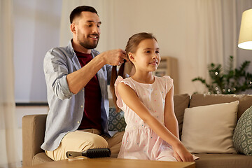 Image showing father braiding daughter hair at home