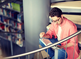 Image showing student boy or young man reading book at library