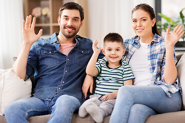 Image showing portrait of happy family waving hands at home