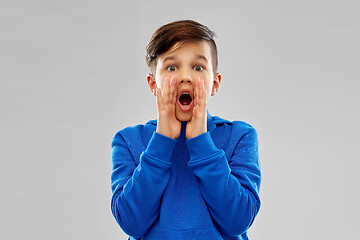 Image showing scared boy in blue hoodie shouting or calling