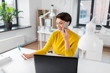 Image showing businesswoman calling on smartphone at office