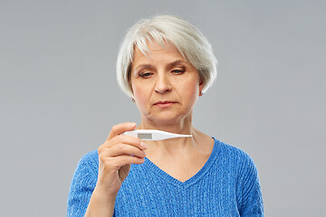 Image showing sick senior woman with thermometer