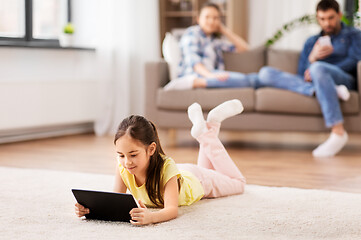 Image showing girl with tablet computer lying on floor at home