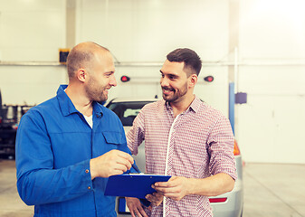 Image showing auto mechanic with clipboard and man at car shop