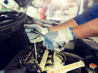 Image showing mechanic man with wrench repairing car at workshop